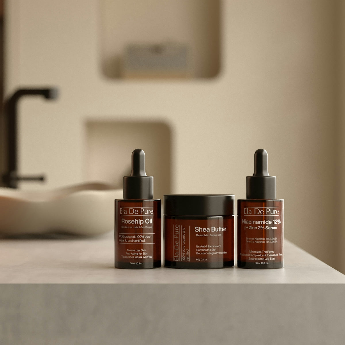 Three skincare bottles and jar on counter