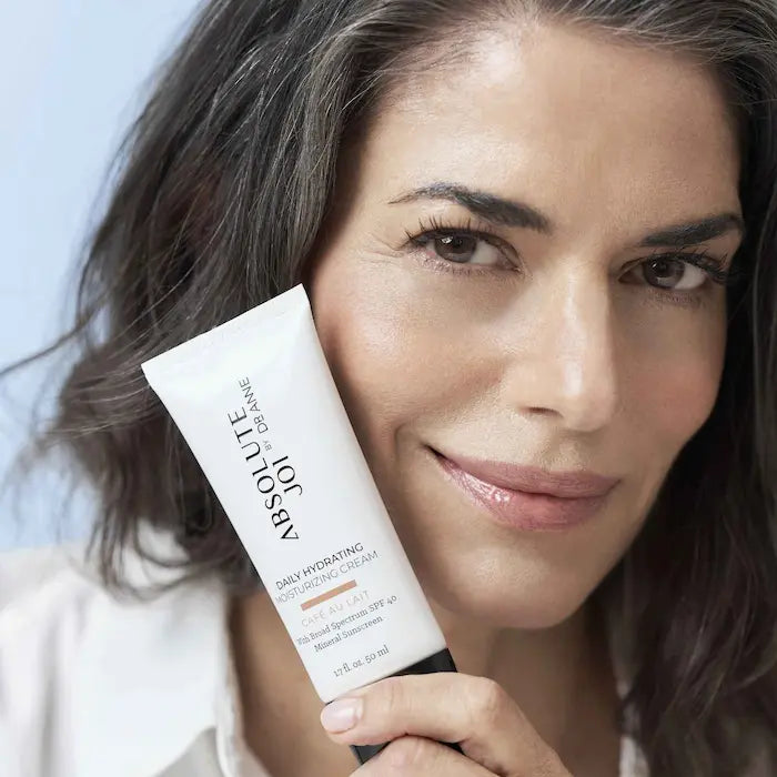 Woman holding a skincare product with a blurred background